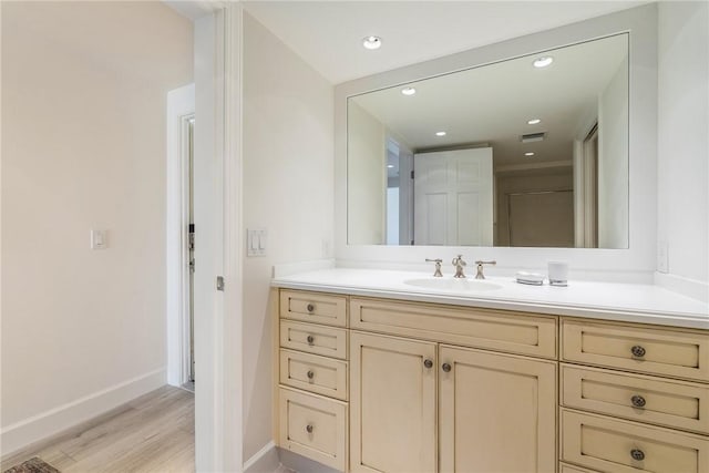 bathroom featuring visible vents, baseboards, recessed lighting, wood finished floors, and vanity