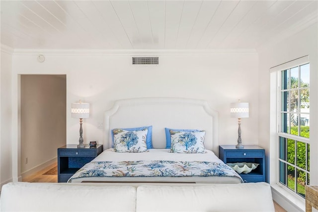 bedroom with visible vents, wood finished floors, crown molding, and wood ceiling