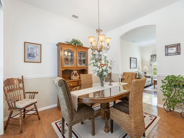 dining room with light wood-type flooring and a notable chandelier