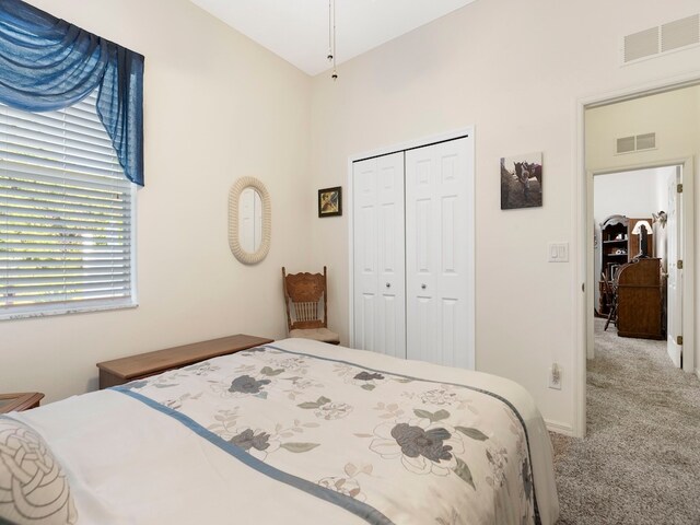 bedroom with light carpet and a closet