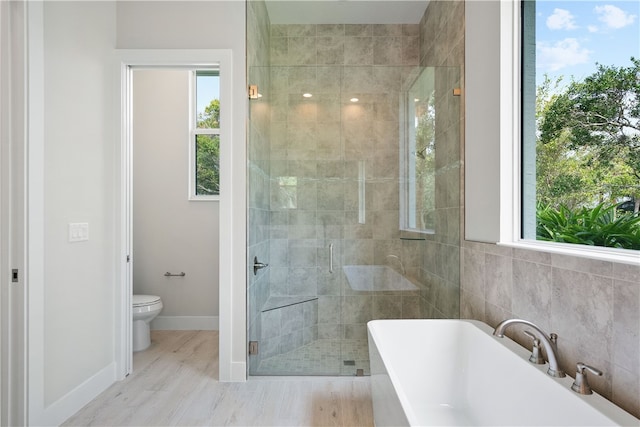 bathroom featuring plus walk in shower, wood-type flooring, and toilet