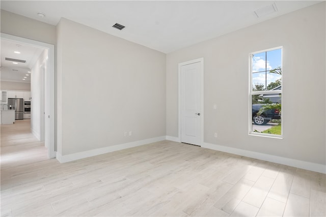 spare room featuring light hardwood / wood-style floors