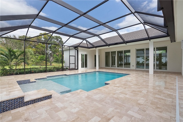 view of pool with glass enclosure and a patio area