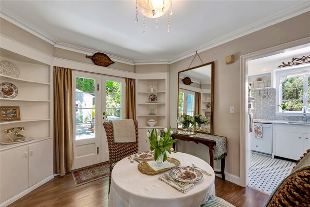 dining area with sink, dark wood-type flooring, and ornamental molding