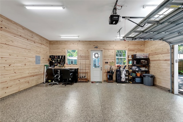 garage featuring electric panel, wooden walls, and a garage door opener