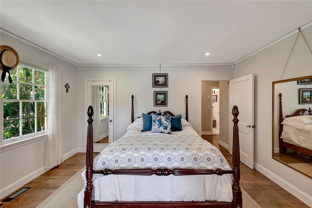 bedroom featuring wood-type flooring and crown molding