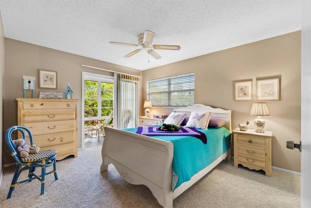 bedroom with multiple windows, ceiling fan, access to outside, and a textured ceiling