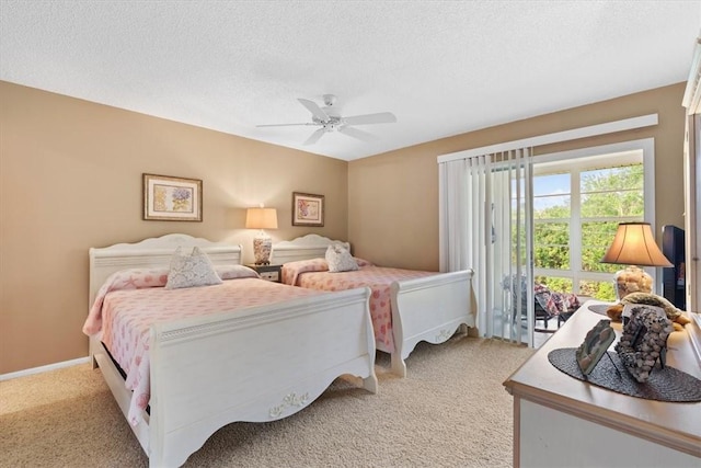 carpeted bedroom featuring ceiling fan and a textured ceiling