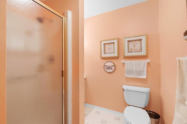 bathroom featuring toilet and a shower with shower door