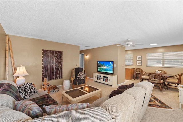 carpeted living room with ceiling fan and a textured ceiling