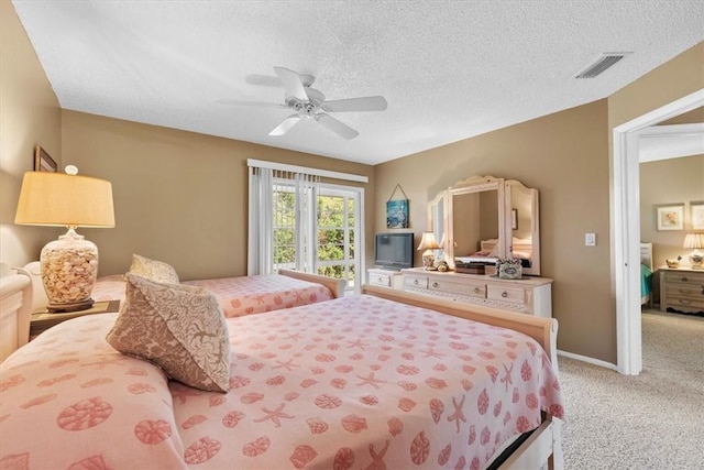 carpeted bedroom with ceiling fan and a textured ceiling