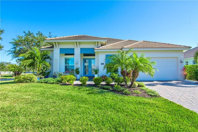 view of front of home with a garage, a front yard, and french doors