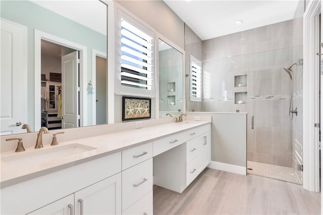 bathroom with vanity, hardwood / wood-style flooring, and a shower with shower door