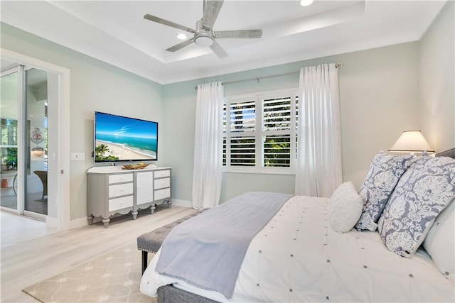 bedroom featuring light wood-type flooring, access to outside, ceiling fan, and a tray ceiling