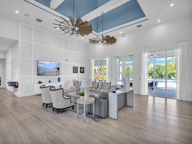 living room with a towering ceiling and ceiling fan