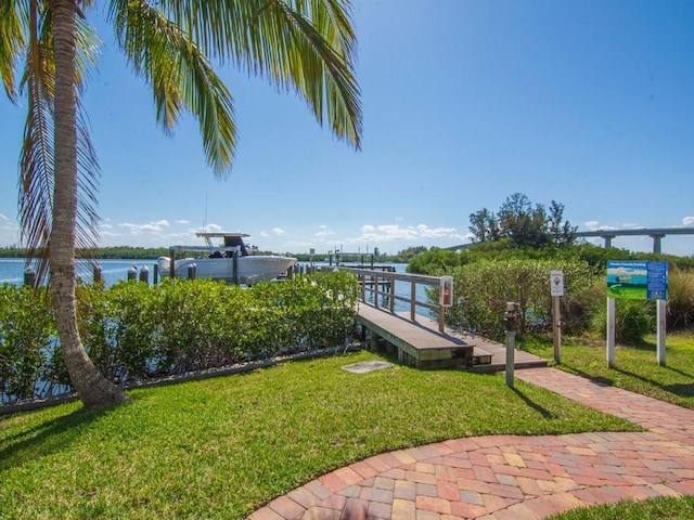 view of dock featuring a water view and a yard