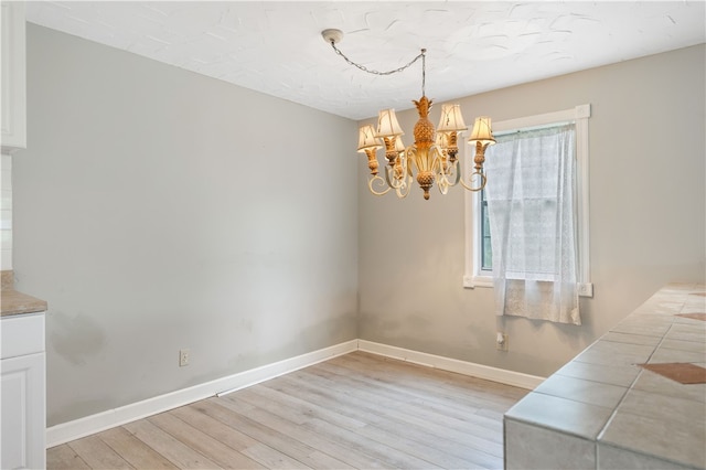 dining space featuring light hardwood / wood-style floors and an inviting chandelier