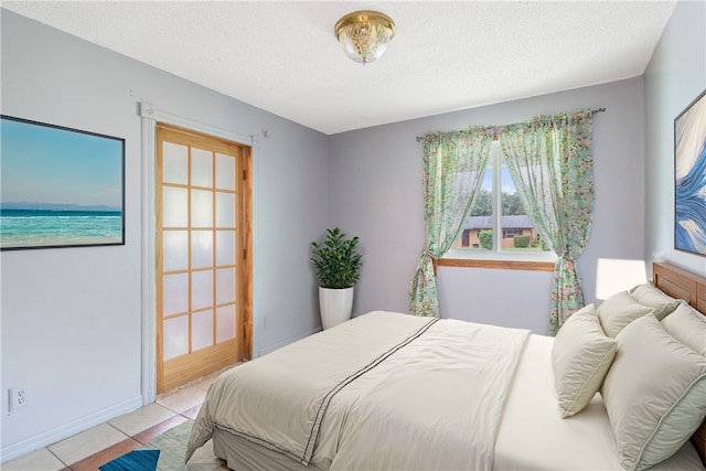 bedroom with light tile patterned floors and a textured ceiling