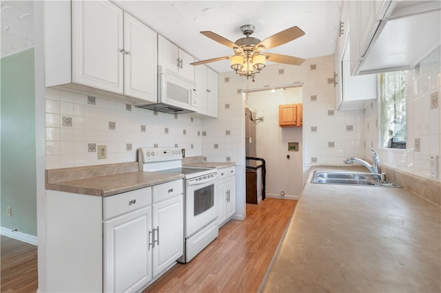 kitchen with light wood-type flooring, white appliances, white cabinetry, and sink