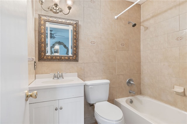 full bathroom with tiled shower / bath, vanity, toilet, and tile walls