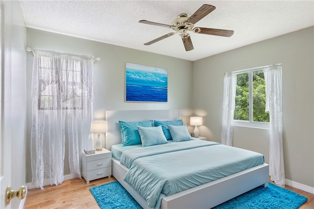 bedroom featuring a textured ceiling, light hardwood / wood-style floors, and ceiling fan