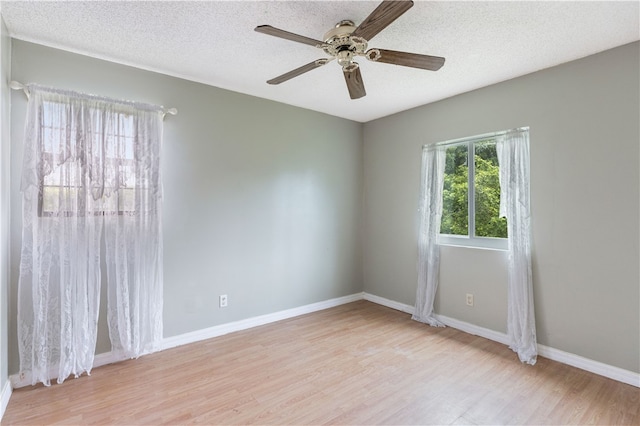 empty room featuring ceiling fan, a textured ceiling, and light hardwood / wood-style flooring