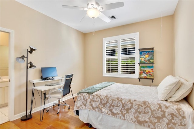 bedroom featuring ceiling fan, hardwood / wood-style floors, and ensuite bath