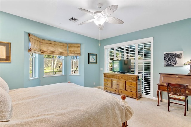 carpeted bedroom featuring multiple windows and ceiling fan