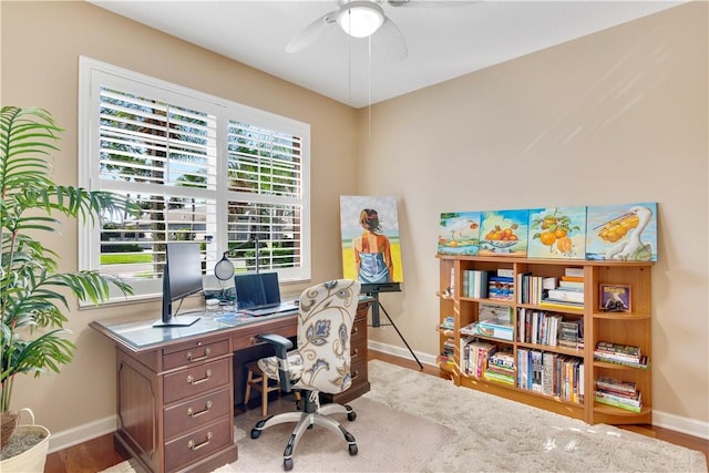 home office with ceiling fan and light hardwood / wood-style floors