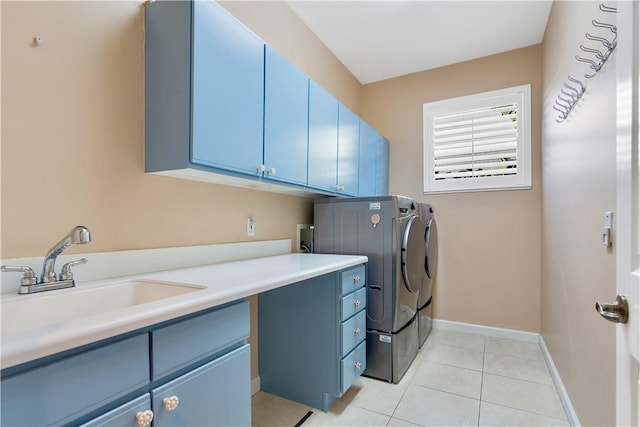 laundry area with sink, washing machine and dryer, light tile patterned floors, and cabinets