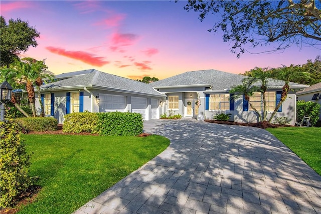 view of front of property with a garage and a yard