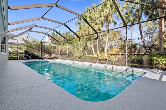 view of pool with glass enclosure and a patio area