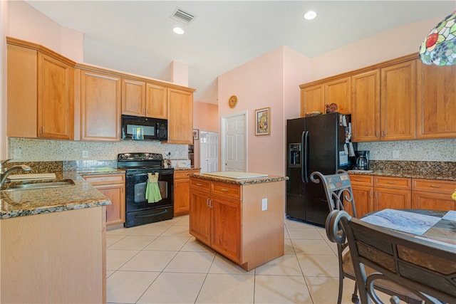 kitchen featuring light tile patterned flooring, sink, black appliances, a center island, and decorative backsplash