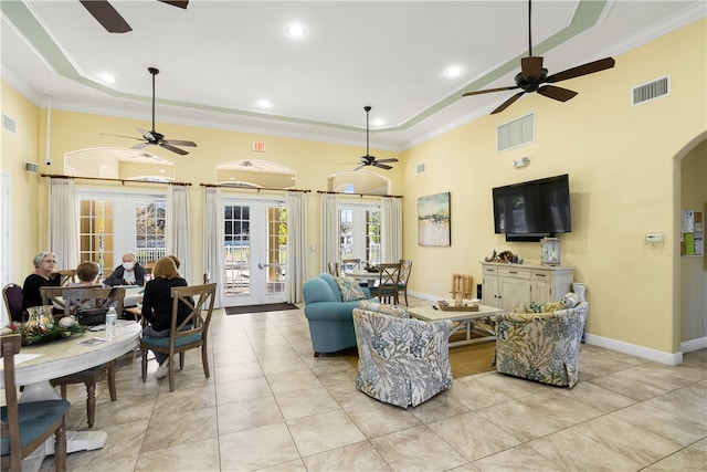 living room with a high ceiling, french doors, light tile patterned flooring, and crown molding