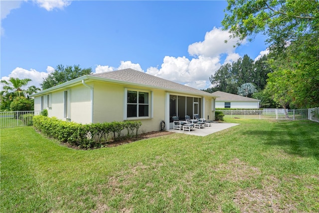 back of property with a lawn and a patio