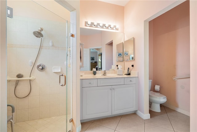 bathroom with toilet, vanity, tile patterned floors, and a shower with door