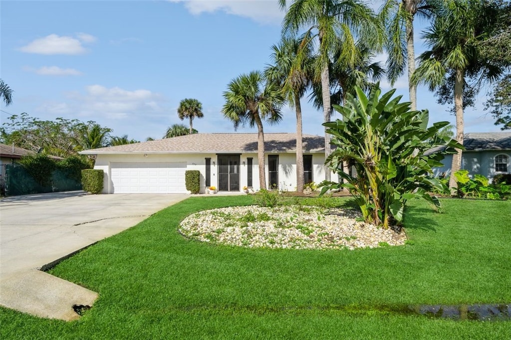 ranch-style home featuring a garage and a front lawn