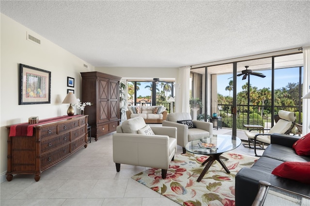 living room featuring light tile patterned floors, a textured ceiling, and expansive windows