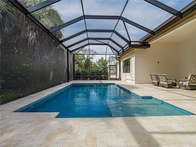 view of pool with a patio and glass enclosure