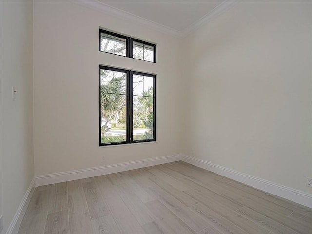 spare room featuring ornamental molding and light hardwood / wood-style flooring