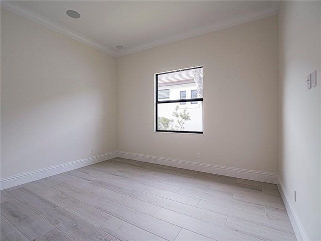 spare room with ornamental molding and light wood-type flooring