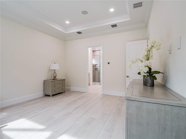 interior space featuring crown molding, light hardwood / wood-style flooring, and a tray ceiling