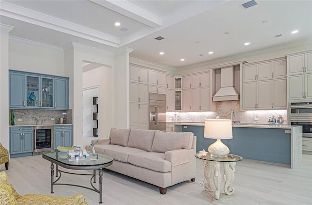 9139 Seaglass Ct, Vero Beach, FL 32963 - living area with wine cooler, light wood-style flooring, recessed lighting, beam ceiling, and ornamental molding