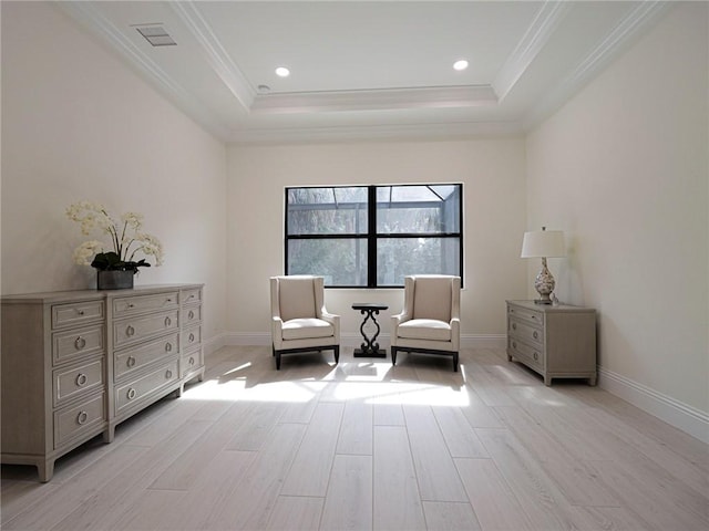 living area with crown molding, light hardwood / wood-style floors, and a tray ceiling