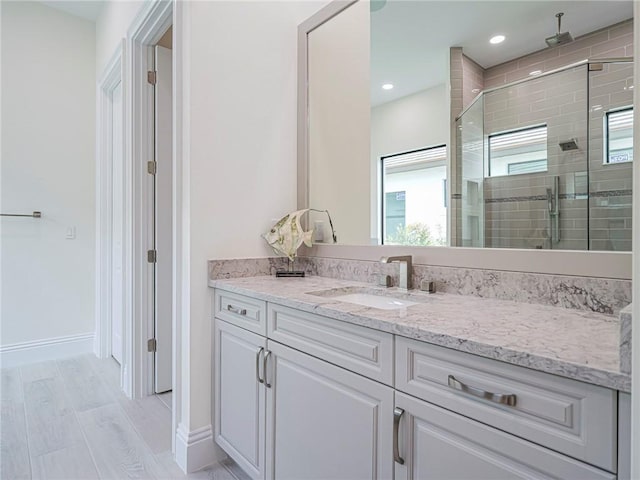 bathroom featuring vanity, hardwood / wood-style floors, and walk in shower