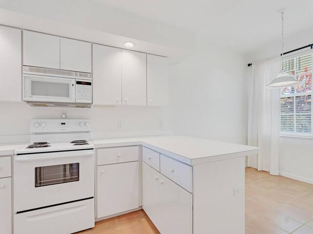 5540 N Harbor Village Dr Unit 103, Vero Beach, FL 32967 - kitchen with white appliances, a peninsula, white cabinets, and light countertops