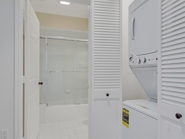 5540 N Harbor Village Dr Unit 103, Vero Beach, FL 32967 - laundry area featuring stacked washer and clothes dryer and light tile patterned flooring
