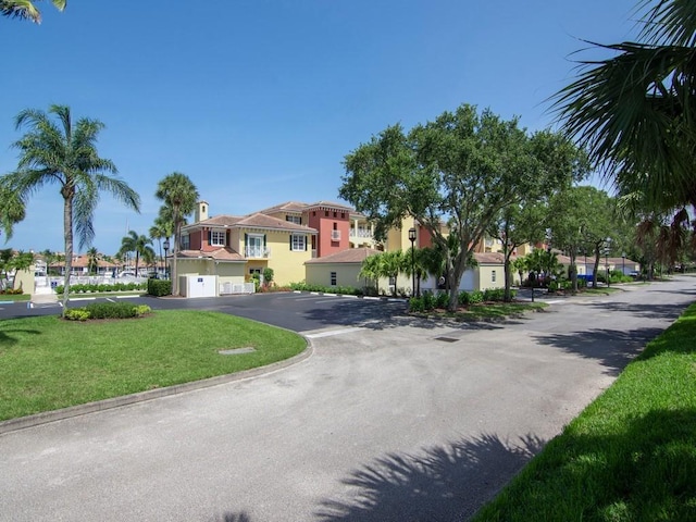 5540 N Harbor Village Dr Unit 103, Vero Beach, FL 32967 - mediterranean / spanish-style house featuring an attached garage, a residential view, and a front lawn