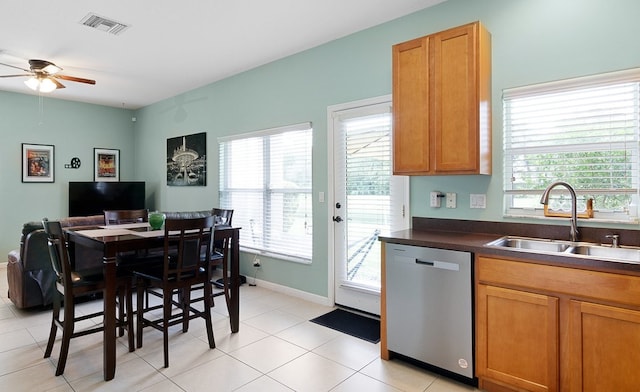 kitchen with a wealth of natural light, stainless steel dishwasher, sink, and ceiling fan