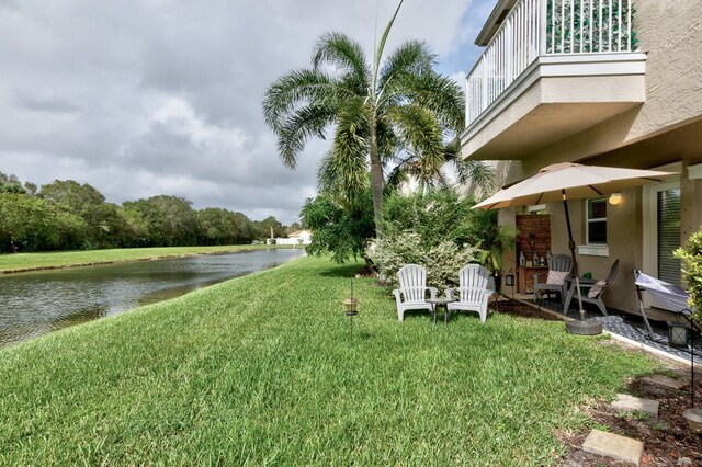 view of yard featuring a balcony, a patio, and a water view